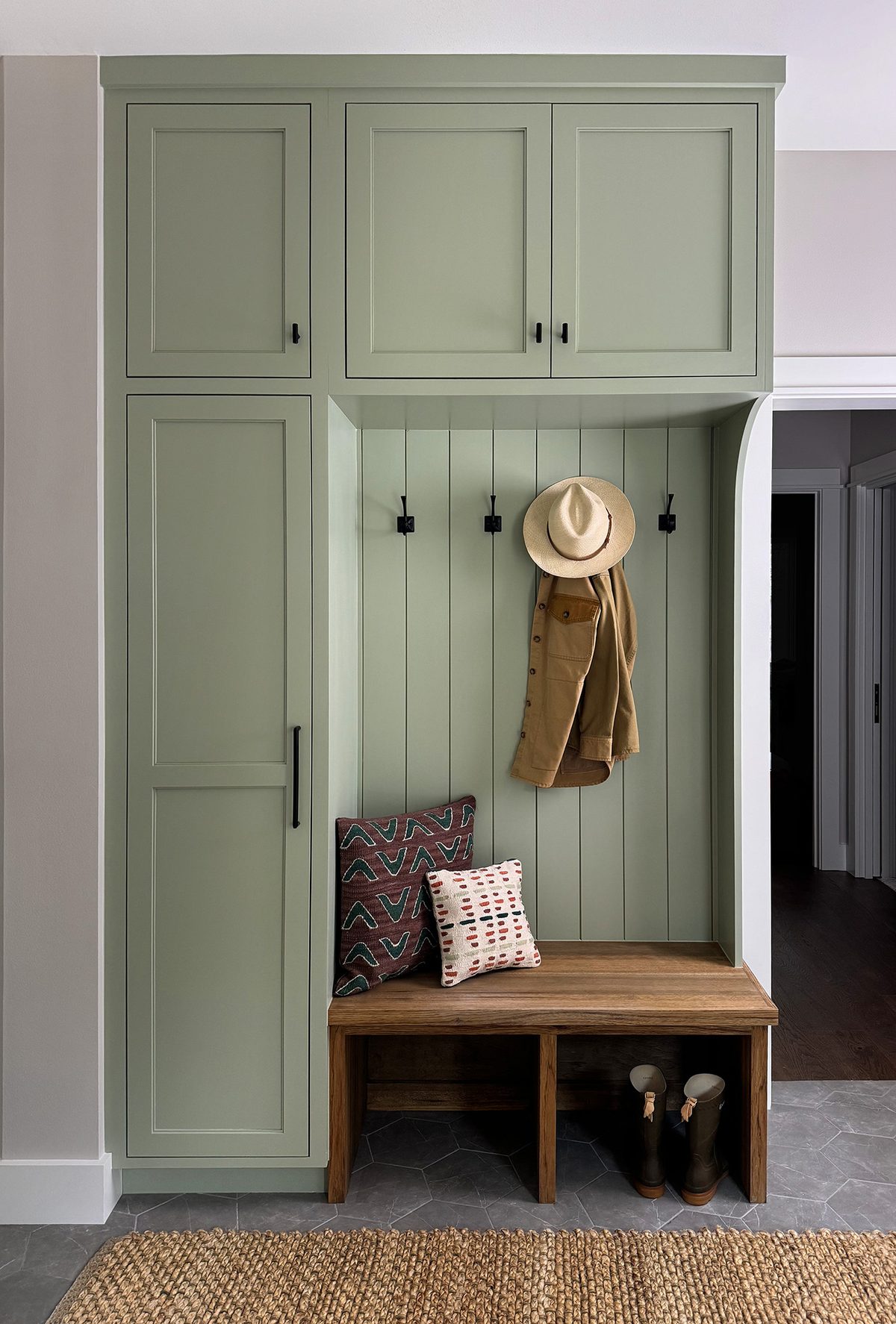 Custom mudroom built-in with full-height painted cabinetry, a shiplap back panel, coat hooks and a solid wood bench with open boot storage.